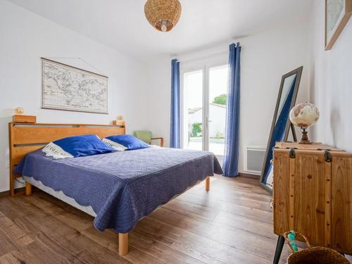 une chambre avec un lit avec des draps bleus et une fenêtre dans l'établissement Maison familiale avec piscine chauffée et terrasse à La Flotte - FR-1-835-20, à La Flotte