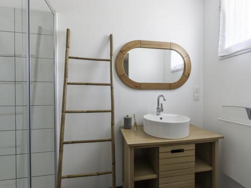 une salle de bain avec un lavabo et un miroir dans l'établissement Maison familiale avec piscine chauffée et terrasse à La Flotte - FR-1-835-20, à La Flotte