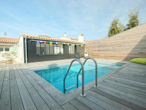 - une piscine sur une terrasse en bois à côté d'une maison dans l'établissement Villa à St-Martin-de-Ré avec piscine chauffée pour 6 pers., 3 chambres - FR-1-835-24, à Saint-Martin-de-Ré