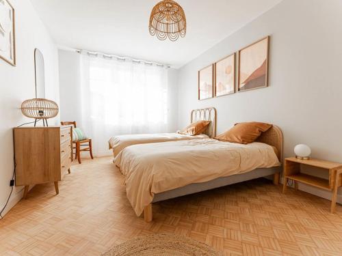 ein Schlafzimmer mit zwei Betten und einem Kronleuchter in der Unterkunft Maison rénovée 2024, proche port et commerces, 3 chambres, parking - FR-1-835-10 in Rivedoux-Plage