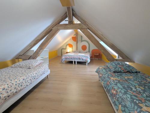 une chambre mansardée avec deux lits et une table dans l'établissement Séjour champêtre avec piscine partagée à Chabris - FR-1-591-739, à Chabris