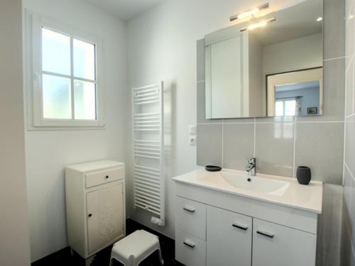 une salle de bain blanche avec un lavabo et un miroir dans l'établissement Maison plain-pied avec jardin pour 6 personnes, proche plage - FR-1-835-11, à La Couarde-sur-Mer