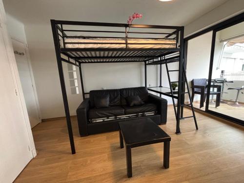 un salon avec un lit mezzanine et un canapé dans l'établissement Studio lumineux à Hendaye, proche plage - FR-1-239-1124, à Hendaye