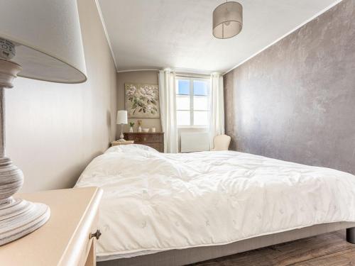 une chambre avec un lit blanc et une fenêtre dans l'établissement Maison familiale à La Noue avec cour privative - FR-1-835-16, à Sainte-Marie de Ré