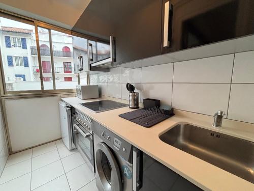 une cuisine avec un évier et une machine à laver dans l'établissement Studio lumineux à Hendaye, proche plage - FR-1-239-1124, à Hendaye