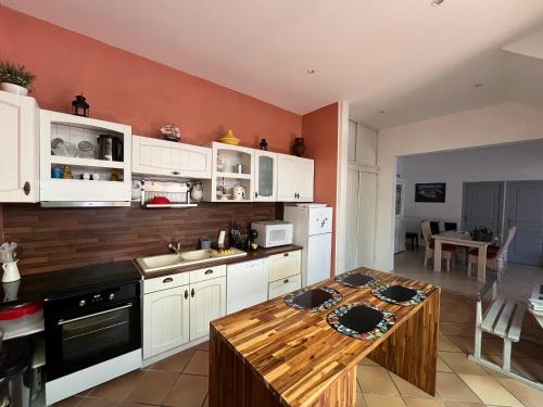 une cuisine avec des armoires blanches et une table en bois dans l'établissement Arcachon - Maison T4 à Deux Pas de la Plage - 6 Pers - FR-1-319-615, à Arcachon