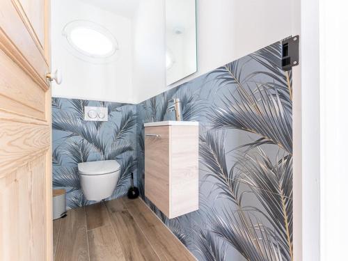 une salle de bain avec une fresque de feuilles de palmier dans l'établissement Maison moderne avec jardin clos pour 4 pers. - FR-1-835-18, au Bois-Plage-en-Ré