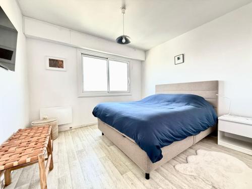 une chambre avec un lit bleu et une fenêtre dans l'établissement Appartement T2 4 pers, 6ème étage avec WiFi, vue mer - FR-1-197-626, à Les Sables-dʼOlonne