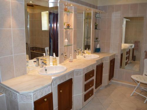 une salle de bain avec deux lavabos et un grand miroir dans l'établissement La Gitelière - FR-1-381-624, à Sainte-Catherine-de-Fierbois