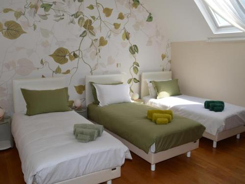 Cette chambre comprend 2 lits avec des oreillers verts et blancs. dans l'établissement La Gitelière - FR-1-381-624, à Sainte-Catherine-de-Fierbois