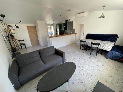 un salon avec un canapé et une table dans l'établissement Maison rénovée au calme, animaux admis, 5 personnes - FR-1-476-239, à Saint-Michel-en-lʼHerm