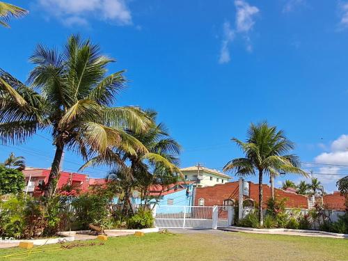 a group of palm trees in front of a house at Pousada Canto da Ilha in Ilha Comprida