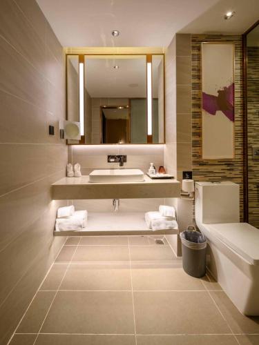 a bathroom with a sink and a tub and a mirror at Lavande Hotel Dongguan Songshan Lake in Dongguan