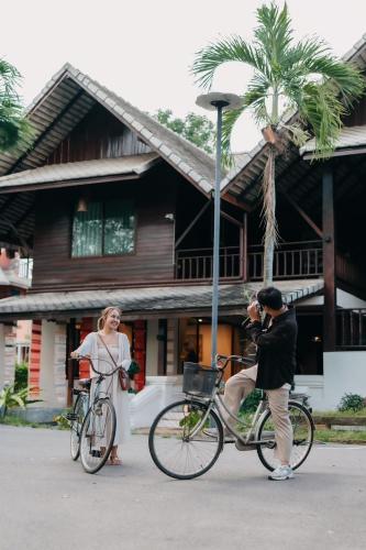 a man riding a bike next to a woman at อภิรตา รีสอร์ท in Nan