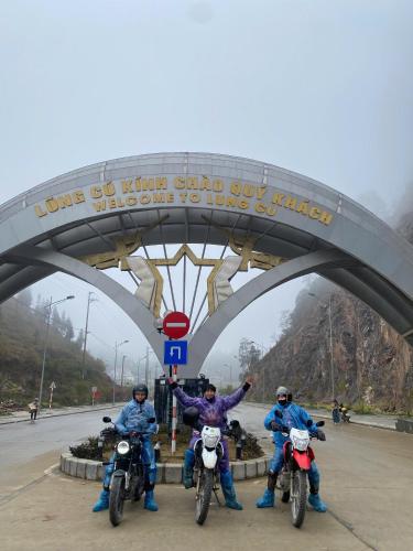 a group of three people on motorcycles under a bridge at Ha Giang Loop Rabbit Hostel & Tours in Ha Giang