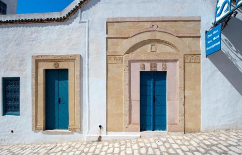 two blue doors on the side of a building at Diar Lemdina Hotel in Hammamet