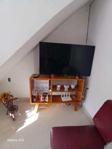 a living room with a flat screen tv on a table at aconchego pe na areia in Ilhéus