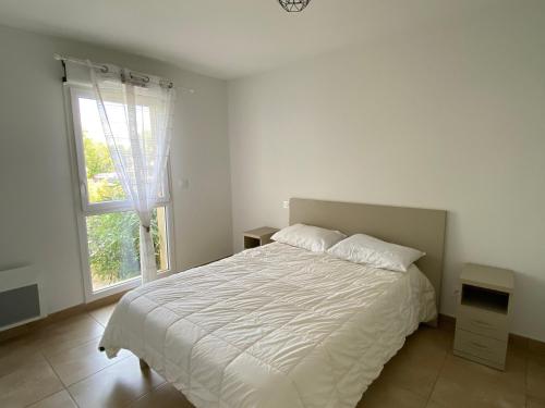 une chambre avec un lit blanc et une fenêtre dans l'établissement T2 Climatisé à Argelès-sur-Mer avec Terrasse, Jardin et Parking - FR-1-732-49, à Argelès-sur-Mer