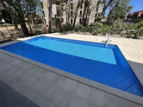 une grande piscine bleue dans une cour dans l'établissement T2 Climatisé à Argelès-sur-Mer avec Terrasse, Jardin et Parking - FR-1-732-49, à Argelès-sur-Mer