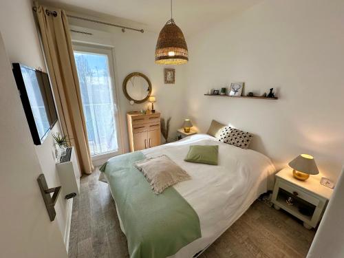 une petite chambre avec un lit et une fenêtre dans l'établissement Charmant 2 pièces, balcon, proche centre-ville Cabourg, 4 pers, parking sécurisé - FR-1-487-360, à Cabourg
