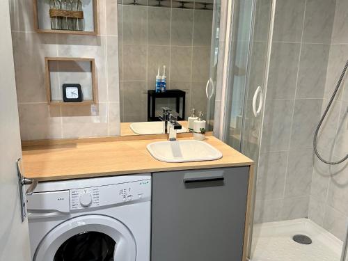 une salle de bain avec une machine à laver et un lavabo dans l'établissement Charmant 2 pièces, balcon, proche centre-ville Cabourg, 4 pers, parking sécurisé - FR-1-487-360, à Cabourg