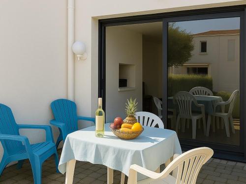 une table avec un bol de fruits et une bouteille de vin dans l'établissement Appartement T2, 4 couchages avec piscine, tennis et parking - Argelès-sur-Mer - FR-1-732-51, à Argelès-sur-Mer