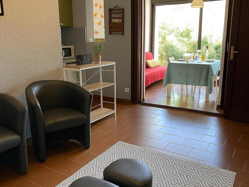 - un salon avec des chaises, une table et une fenêtre dans l'établissement Appartement T2, 4 couchages avec piscine, tennis et parking - Argelès-sur-Mer - FR-1-732-51, à Argelès-sur-Mer