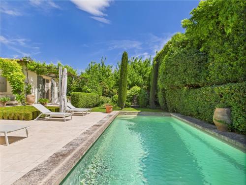 une piscine devant une maison avec des arbres dans l'établissement Superbe Maison Climatisée avec Piscine au Cœur de Maussane - Proche Commerces et Activités! - FR-1-599-83, à Maussane-les-Alpilles