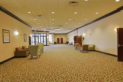 a large waiting room with chairs and tables at Hotel Gurnee in Gurnee