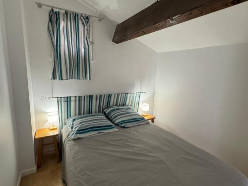 une chambre avec un lit avec deux oreillers dessus dans l'établissement Maison plain-pied à Argelès-sur-Mer avec garage, proche transports et commerces - FR-1-732-87, à Argelès-sur-Mer