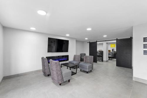 a waiting room with chairs and a table and a tv at Baymont by Wyndham San Antonio Near Lackland AFB in San Antonio