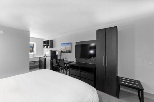 a bedroom with a bed and a desk with a television at Baymont by Wyndham San Antonio Near Lackland AFB in San Antonio