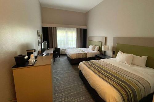 ein Hotelzimmer mit zwei Betten und einem Fernseher in der Unterkunft Travelodge by Wyndham Knoxville West in Knoxville