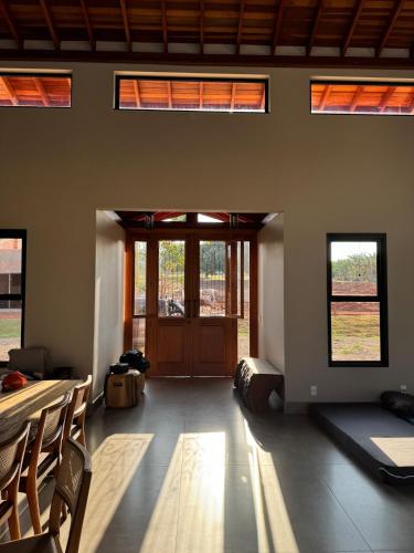 a large room with a door and a room with windows at Casa de Campo Paraíso na canastra in Delfinópolis