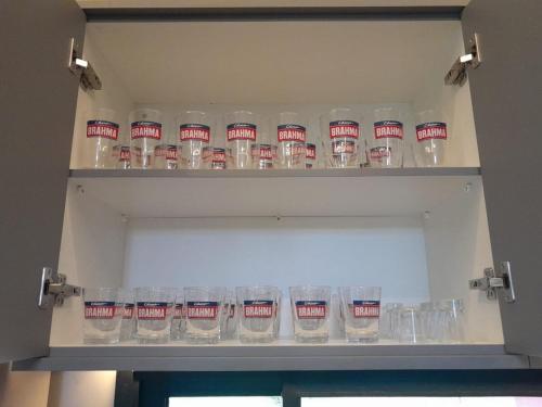 a shelf full of empty glasses in a cabinet at Casa de Campo Paraíso na canastra in Delfinópolis