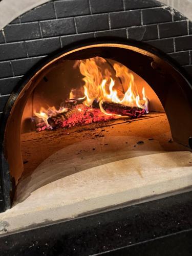 a brick oven with a fire inside of it at Casa de Campo Paraíso na canastra in Delfinópolis