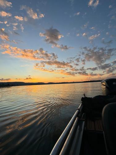 a boat on a body of water at sunset at Casa de Campo Paraíso na canastra in Delfinópolis