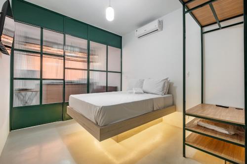 a bedroom with a bed and a green wall at Apartamentos inCircle in Sao Paulo