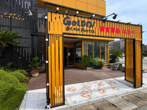 a yellow building with a sign on the front of it at ゴールデンビーチホテル in Katakai