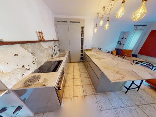 - une cuisine avec des comptoirs en marbre et un évier dans l'établissement Calme 2P avec terrasse et jardin, parking et piscine - FR-1-196-382, à Menton