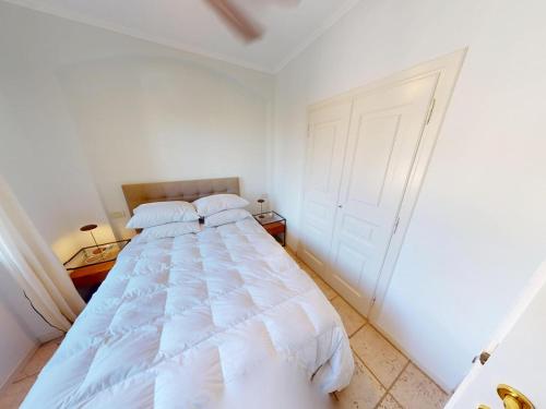 une chambre avec un lit blanc avec deux oreillers dans l'établissement Calme 2P avec terrasse et jardin, parking et piscine - FR-1-196-382, à Menton