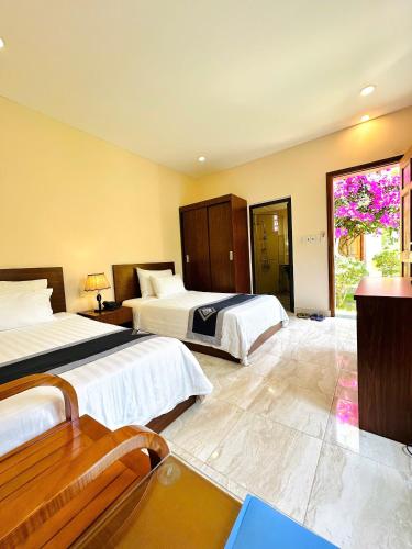 a hotel room with two beds and a window at Aloha Bình Tiên-Thôn Bình Tiên, Công Hải, Thuận Bắc, Ninh Thuận, Việt Nam in Phan Rang