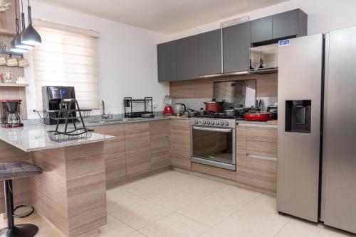 a kitchen with a stainless steel refrigerator and a counter at AdyHouse Tres Cantos in Cedro