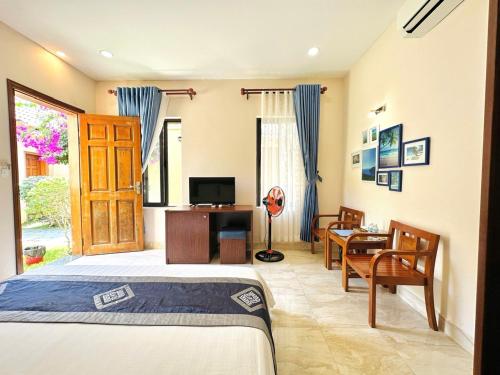 a bedroom with a bed and a desk and a television at Aloha Bình Tiên-Thôn Bình Tiên, Công Hải, Thuận Bắc, Ninh Thuận, Việt Nam in Phan Rang