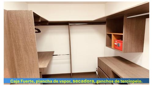 a kitchen with white walls and wooden cabinets and a refrigerator at AdyHouse Tres Cantos in Cedro