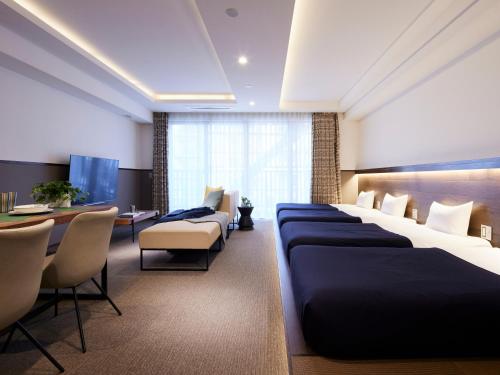 une chambre d'hôtel avec des lits, une table et des chaises dans l'établissement Minn Asakusa, à Tokyo