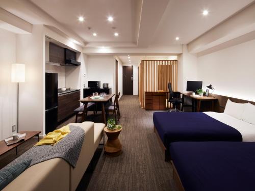 a hotel room with two beds and a living room at Minn Asakusa in Tokyo