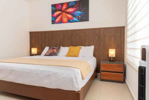 a bedroom with a large bed with a wooden headboard at AdyHouse Tres Cantos in Cedro