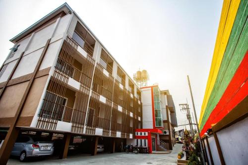 a building with a car parked in front of it at Smile Place Hotel Chiang Rai in Chiang Rai