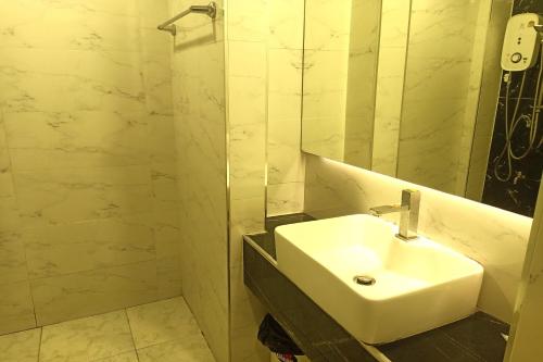 a bathroom with a white sink and a mirror at Smile Place Hotel Chiang Rai in Chiang Rai